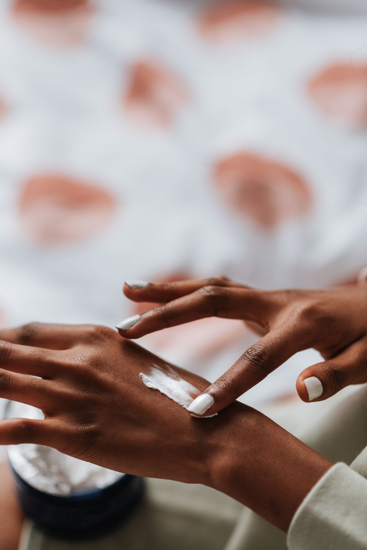 Hands applying skincare cream