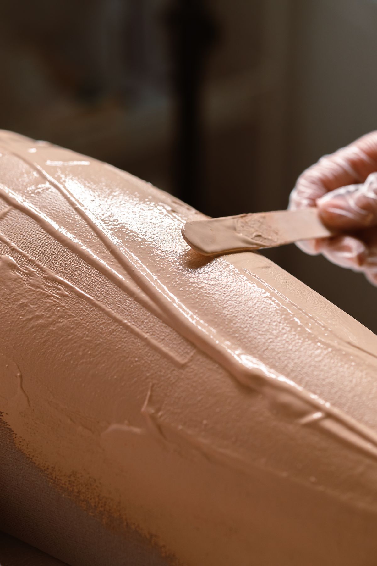 Warm wax being spread with a spatula